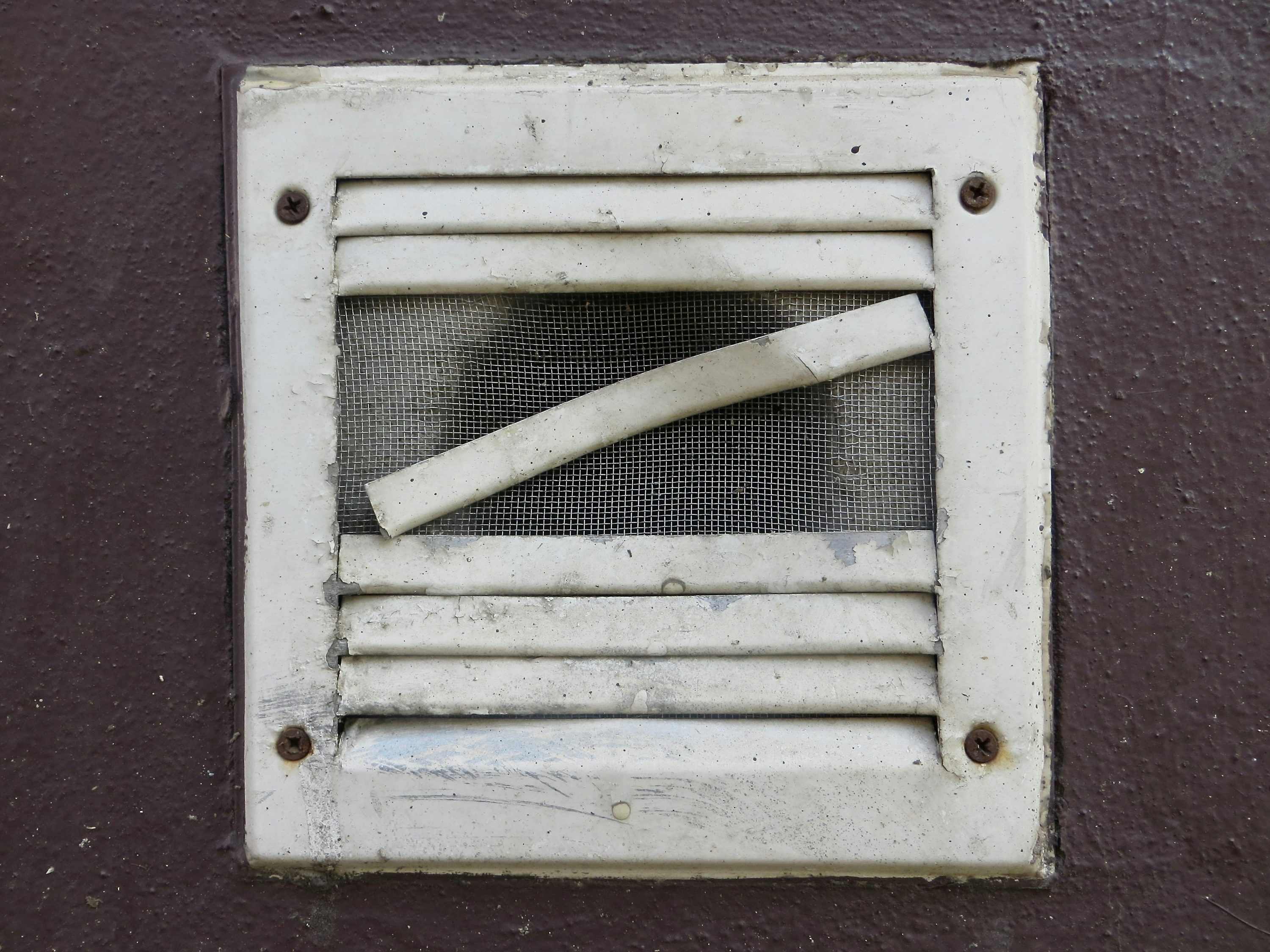 A damaged exterior vent cap that needs repair